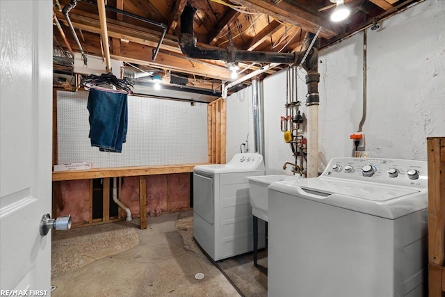 clothes washing area with laundry area, washing machine and dryer, and a sink