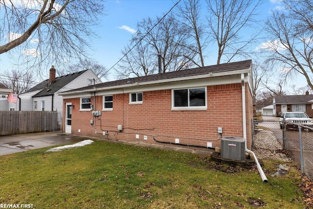 rear view of property with brick siding, a lawn, crawl space, fence, and cooling unit