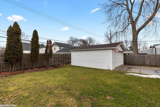 view of yard featuring an outbuilding, driveway, a detached garage, and fence