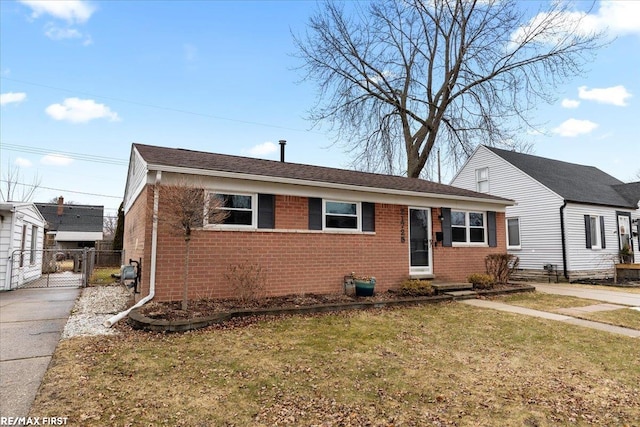 view of front of property with brick siding, a front yard, fence, and a gate