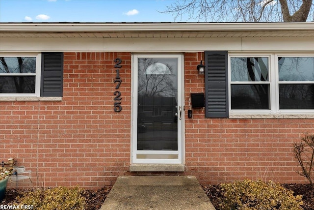 doorway to property featuring brick siding