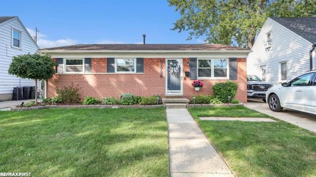 bungalow with brick siding and a front yard