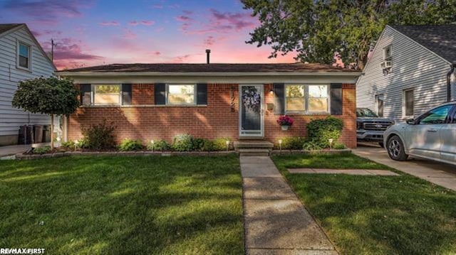 view of front of house with brick siding and a front lawn