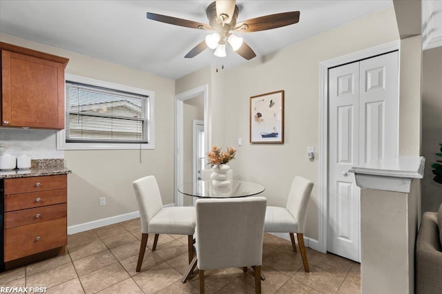 dining room featuring light tile patterned floors, a ceiling fan, and baseboards