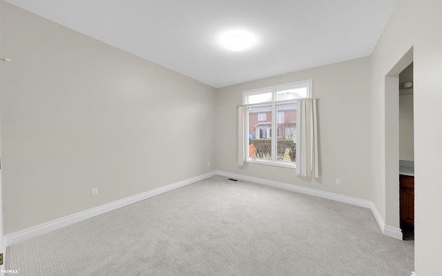 empty room with light carpet and baseboards