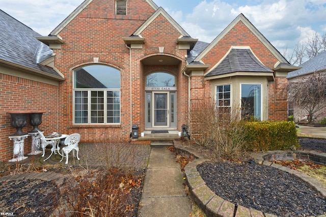 traditional home with brick siding and roof with shingles