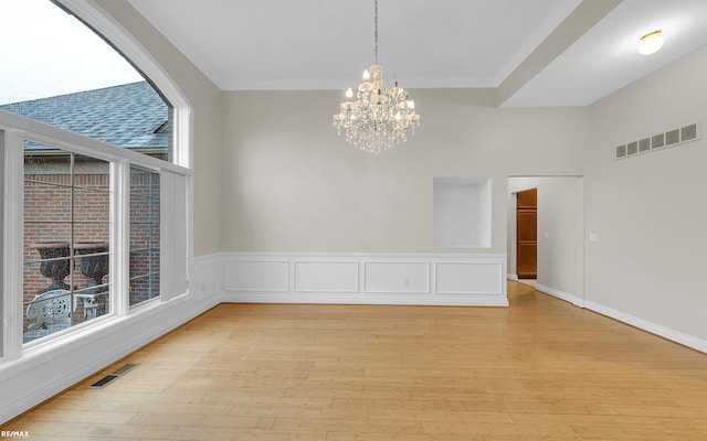 spare room featuring a chandelier, visible vents, and light wood-style flooring