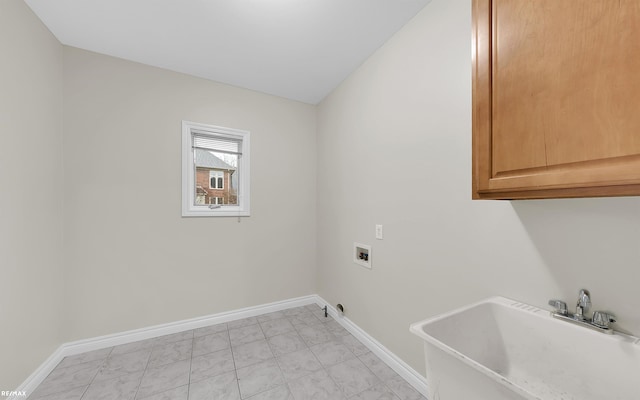 washroom with hookup for a washing machine, a sink, cabinet space, and baseboards