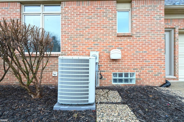 details featuring central air condition unit and brick siding