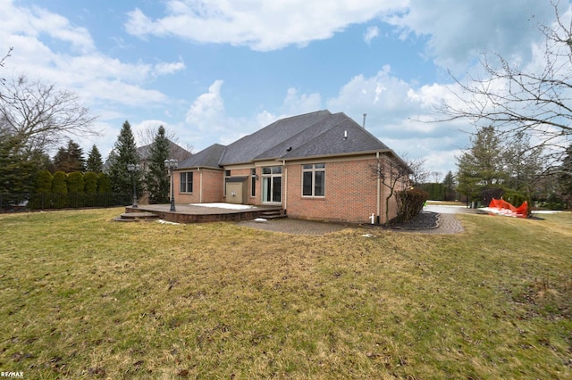 back of house with brick siding, a yard, and a patio