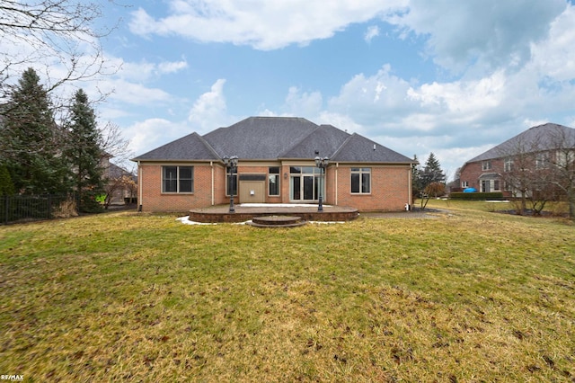 rear view of house with a patio area, a lawn, and brick siding