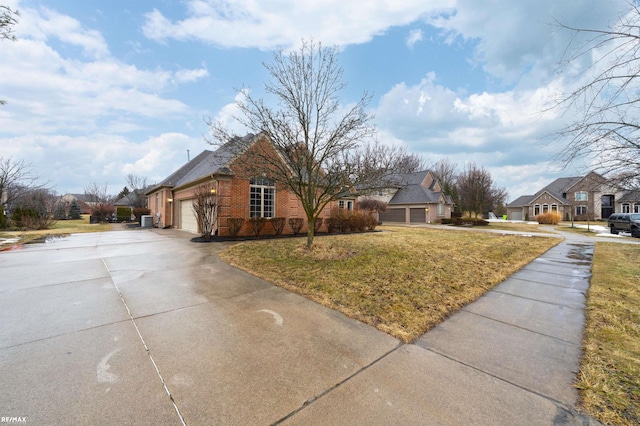 view of front of property with brick siding, concrete driveway, a front yard, a garage, and a residential view