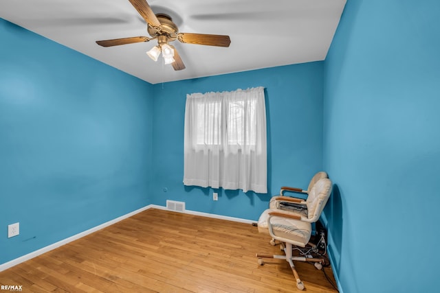 unfurnished room featuring hardwood / wood-style flooring, baseboards, visible vents, and a ceiling fan