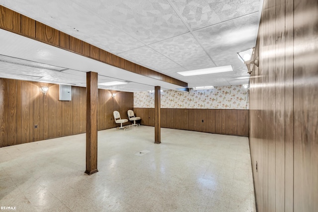 finished basement with wood walls and tile patterned floors