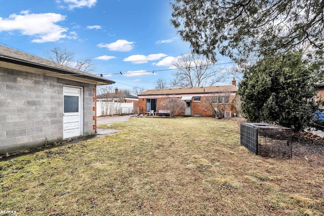 view of yard featuring fence and central AC