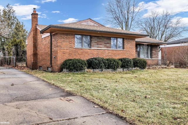 view of home's exterior featuring a yard, a chimney, fence, and brick siding