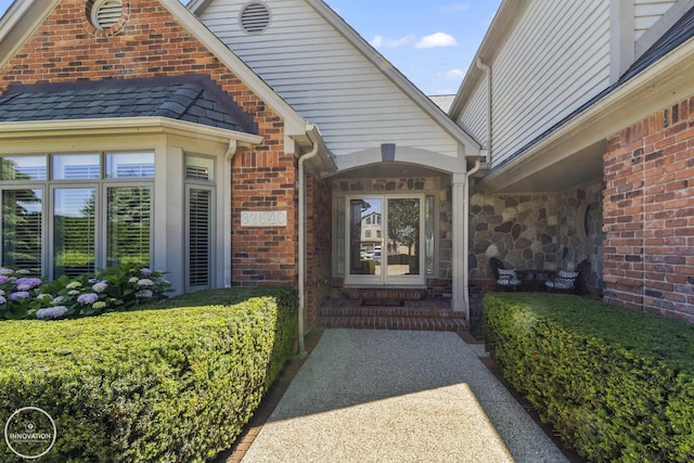 entrance to property featuring stone siding and brick siding