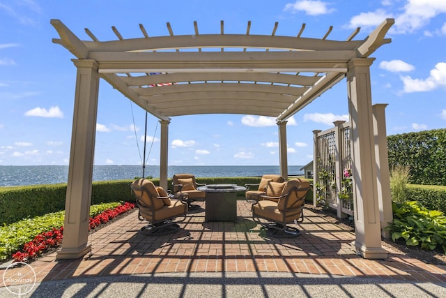 view of patio with a water view, a fire pit, and a pergola