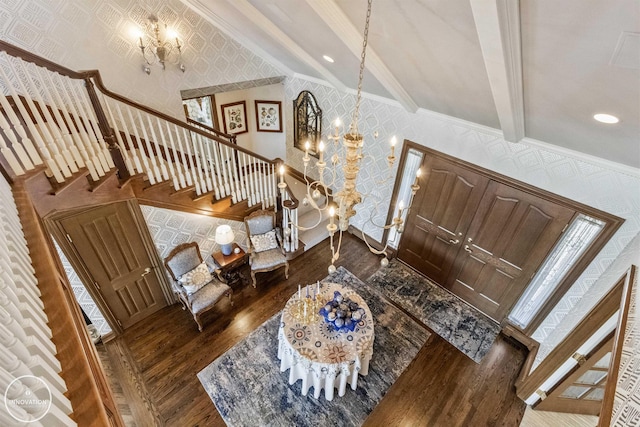 foyer featuring a chandelier, stairway, wood finished floors, and wallpapered walls