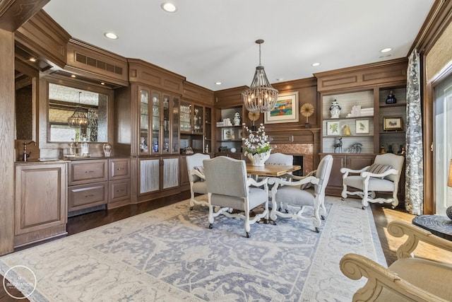 dining area with a chandelier, a high end fireplace, recessed lighting, and wood finished floors