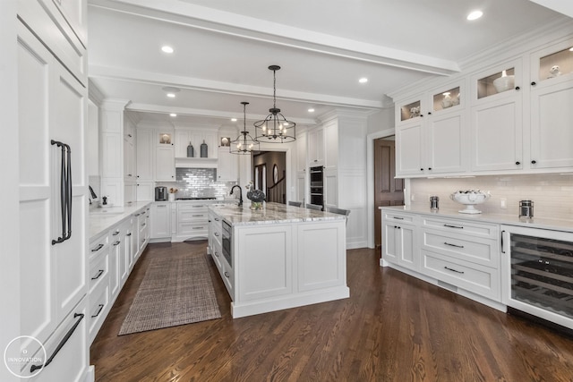 kitchen with wine cooler, beam ceiling, a sink, and white cabinetry