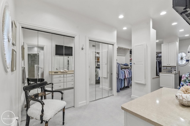 walk in closet featuring light colored carpet