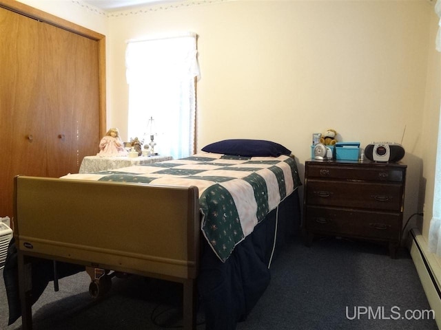 carpeted bedroom featuring a baseboard heating unit