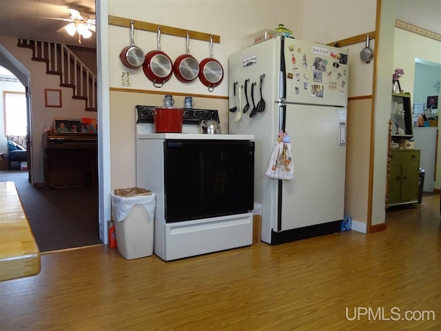 kitchen featuring ceiling fan, freestanding refrigerator, wood finished floors, and range with electric stovetop