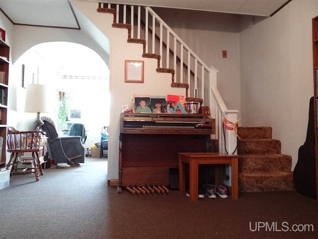 sitting room with carpet, stairs, arched walkways, and crown molding