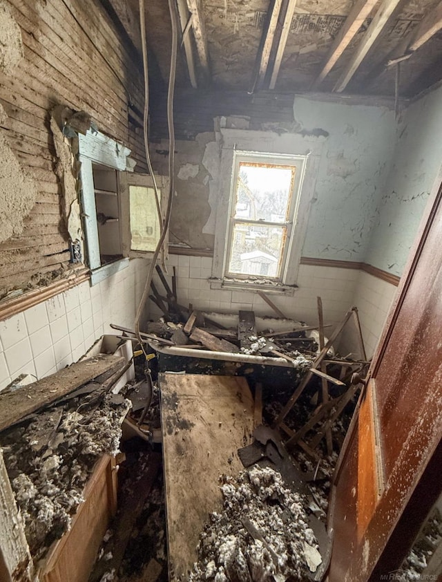 miscellaneous room with a wainscoted wall