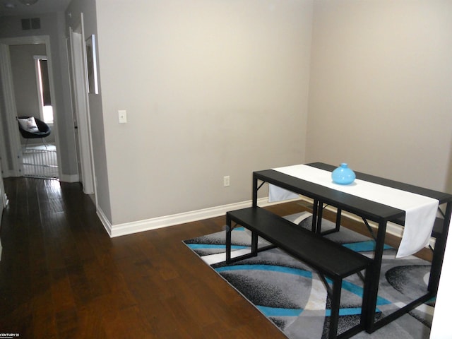 dining room with dark wood-style floors, visible vents, and baseboards