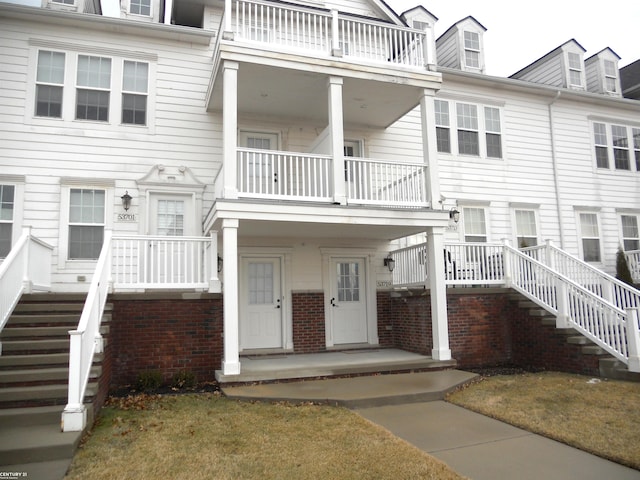 townhome / multi-family property featuring covered porch and a balcony