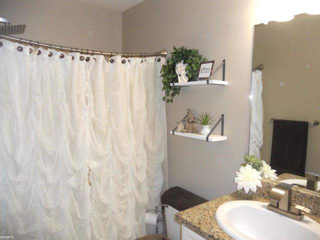 full bathroom featuring curtained shower, vanity, and toilet