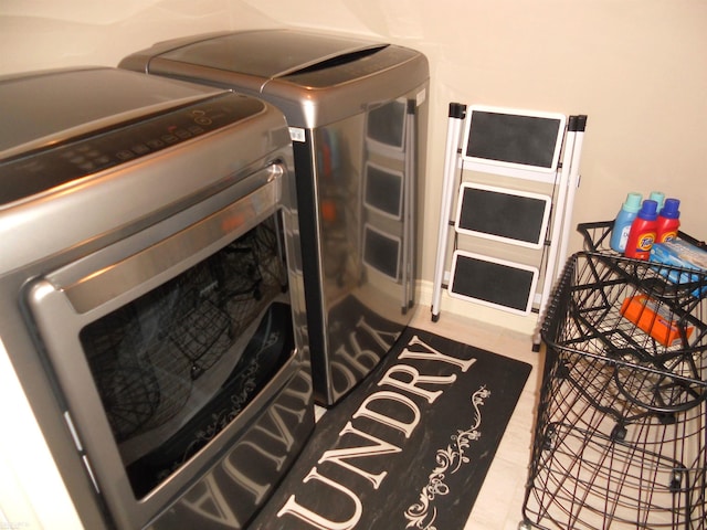 laundry area featuring laundry area, washing machine and clothes dryer, and tile patterned floors