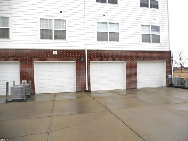 garage with driveway and central air condition unit