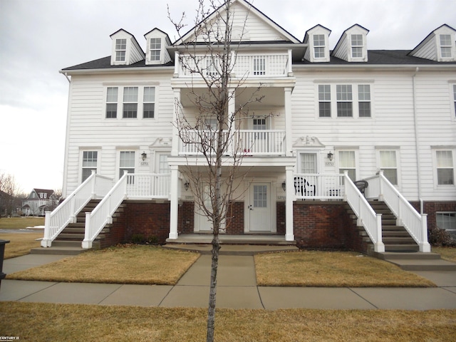 townhome / multi-family property with a porch and a balcony