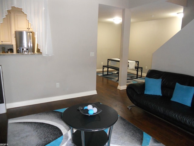 living room featuring dark wood-type flooring and baseboards