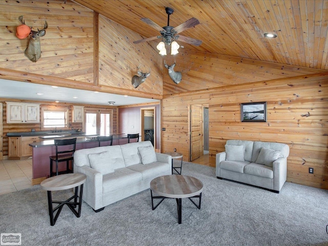 living room with wooden walls, a ceiling fan, wood ceiling, high vaulted ceiling, and light tile patterned flooring