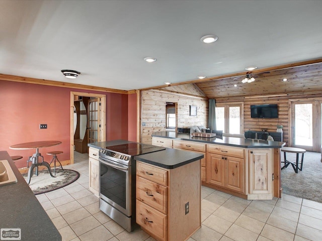 kitchen featuring a center island, stainless steel electric range oven, dark countertops, rustic walls, and light brown cabinetry