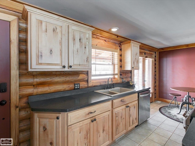 kitchen with log walls, dark countertops, stainless steel dishwasher, light brown cabinetry, and a sink