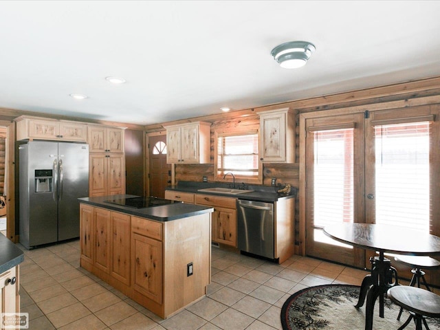 kitchen featuring light tile patterned floors, stainless steel appliances, dark countertops, a kitchen island, and a sink