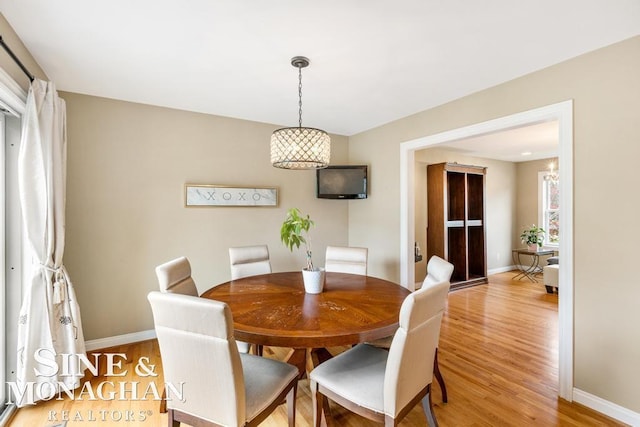 dining area with light wood-type flooring and baseboards