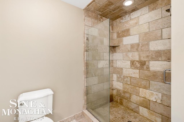 full bath featuring a shower stall and toilet