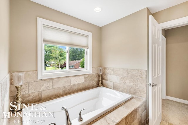 bathroom with baseboards and a bath