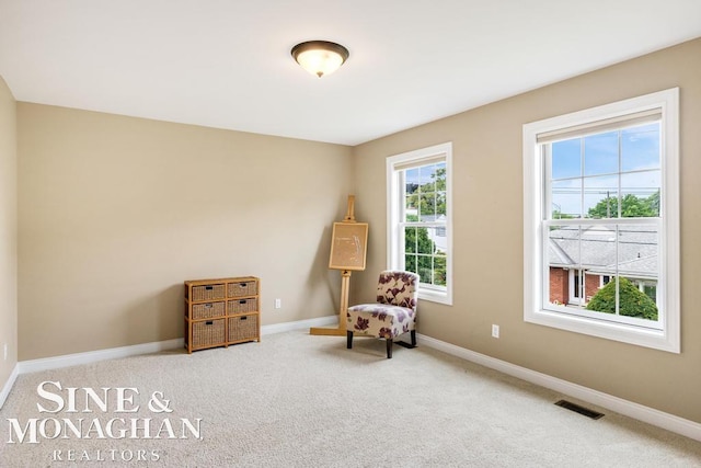 living area with baseboards, visible vents, and carpet flooring