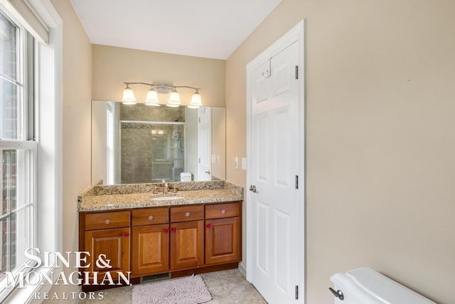 bathroom featuring a stall shower, vanity, toilet, and tile patterned floors