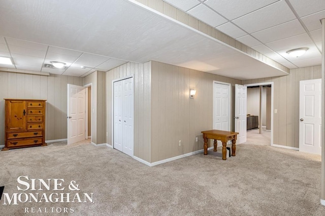 basement featuring carpet floors, a paneled ceiling, and baseboards