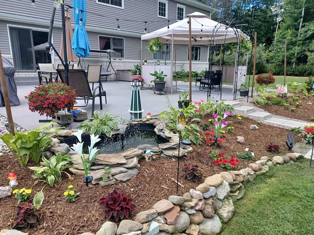 view of yard featuring a patio, a small pond, and fence