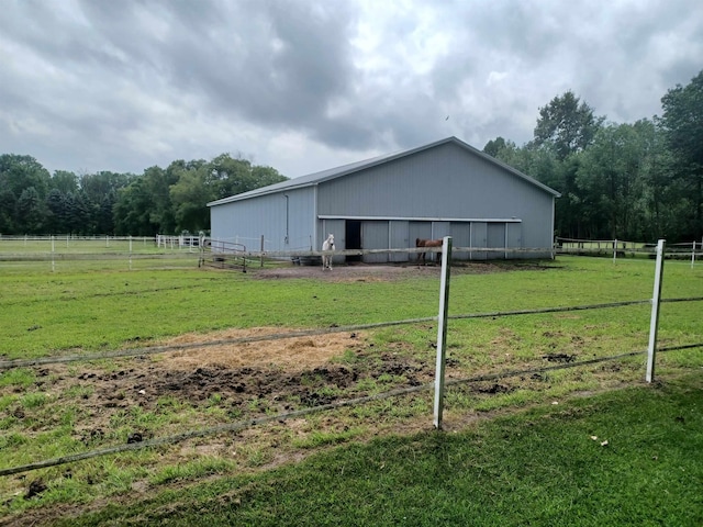 view of side of home with an outbuilding, a pole building, and a rural view