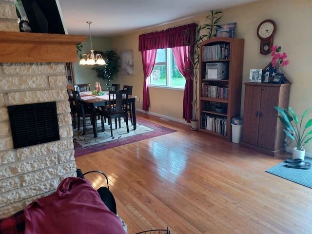 dining room with a chandelier, hardwood / wood-style floors, and baseboards